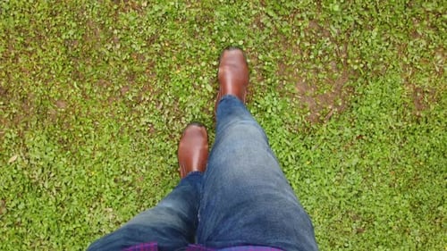 Mann im Schuh läuft auf einer grünen Oberfläche