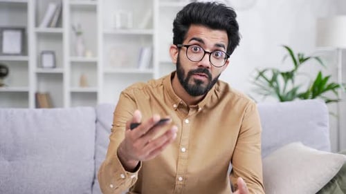 Webcam view. Confident teacher in glasses talking on video call while sitting in home office looking