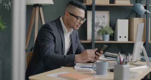 Portrait of Businessman Using Computer and Smartphone Working in Office Alone