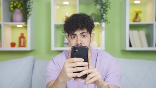 Young Adult Using Smartphone in Living Room