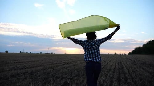 Ukrainian Woman Running with Raised Flag Ukraine Above Her Head on Wheat Field at Sunset Lady