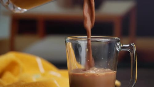 Glass of Chocolate Milk with Blender Pouring Chocolate
