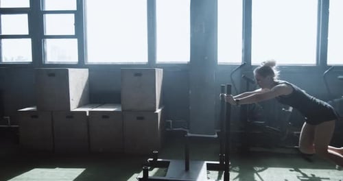 Dolly Shot Young Athletic Blonde Woman Working Out with Functional Training Sled in Big Atmospheric