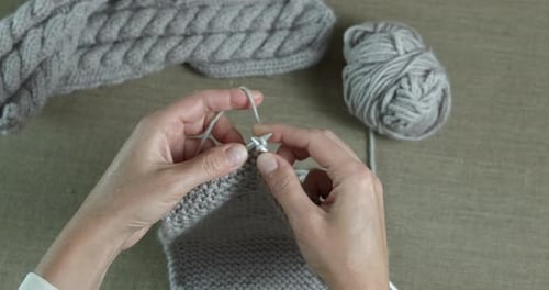 Hands Knitting Gray Yarn with Needles Close Up