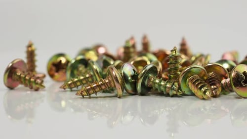 Metal screws on a white background. Rotating screws for driving into plastic.