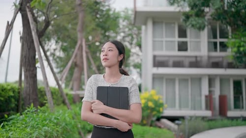 Woman with a calm face walks along a shady path, surrounded by lush greenery, against a backdrop