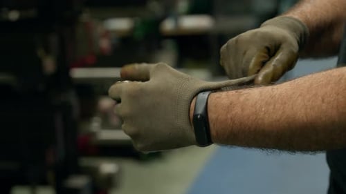 Factory Worker Putting on Protective Gloves