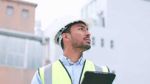 Thinking, content construction engineer typing on a tablet while onsite for inspection