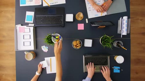 Young entrepreneurs collaborating on app design at office table top view