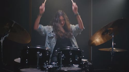 Enthusiastic Woman Playing Drums in Studio Setting