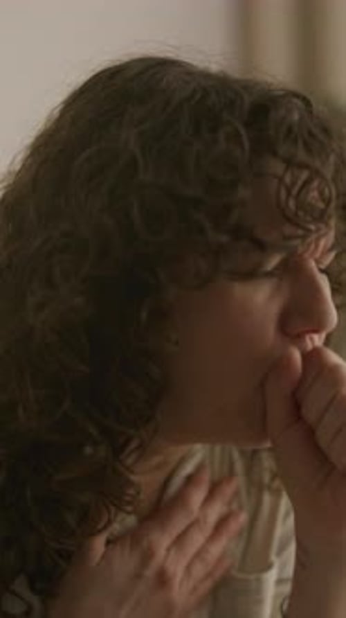 Woman Coughing and Holding Her Chest Indoors