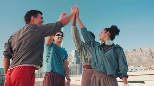 Athletic Young Adults Give High Five in City