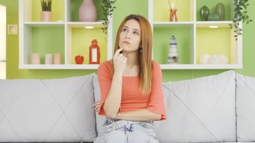 Woman Sitting Thoughtfully on Couch Pondering Choices