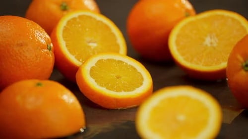 Half of an Orange and a Piece Fall on the Table and Lie Nicely