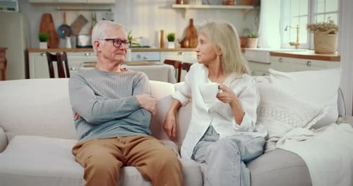Senior Couple Conversing on Couch Indoors