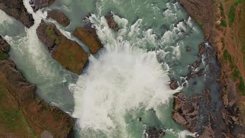 Epic Aerial View of a Powerful Waterfall Rushing Over Rocks