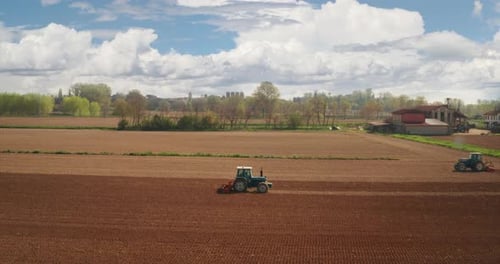 Aerial shot of farming tractor is plowing and cultivating field for future sowing new crops with p