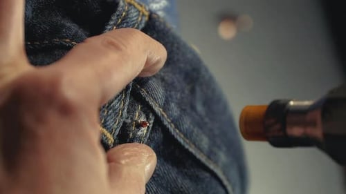 Attaching Button to Blue Denim Jeans with Tool