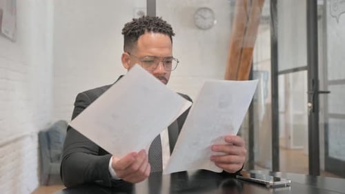 Excited Businessman Reads Positive Documents in Office