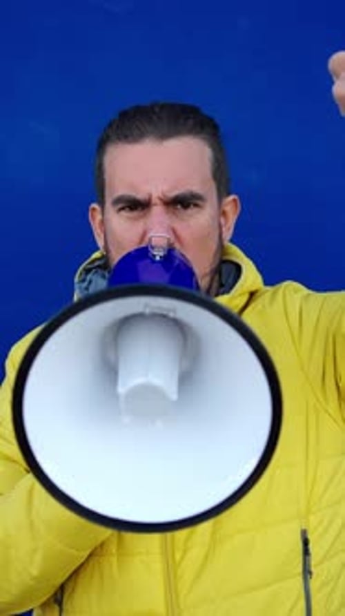 Adult Man Shouting into Megaphone with Raised Fist