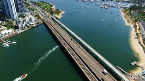Luftaufnahme der Sundale Bridge, Gold Coast Highway, vorbeifahrende Boote, die sich langsam auf einer Brücke vorwärts bewegen