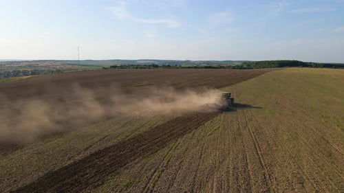 Aerial View of Tractor Plowing Agricultural Farm Field Preparing Soil for Seeding in Summer