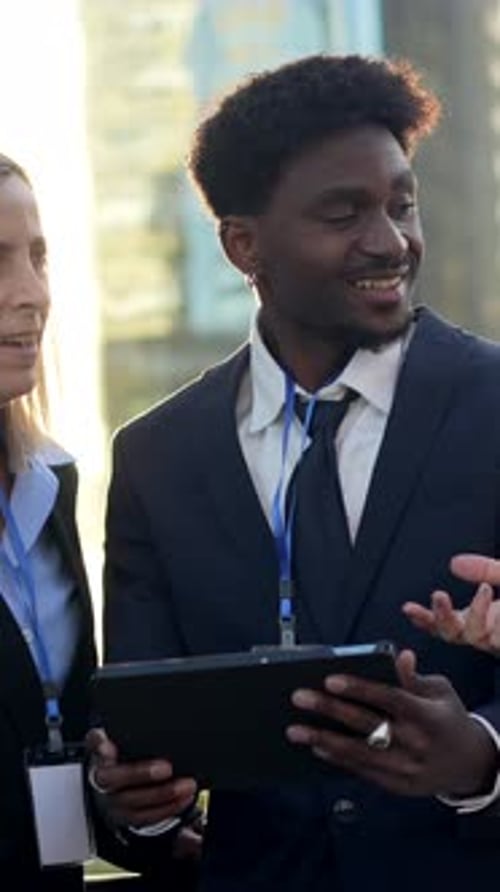 Business People Reviewing Tablet Outdoors in Urban Setting