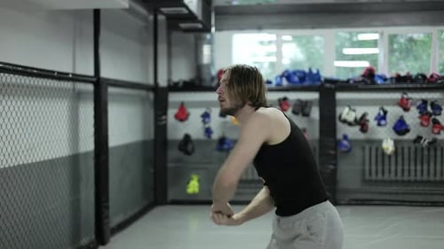 Young Man Stretching and Warming Up in Gym