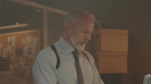 Man Sorting Through Box of Files in Office