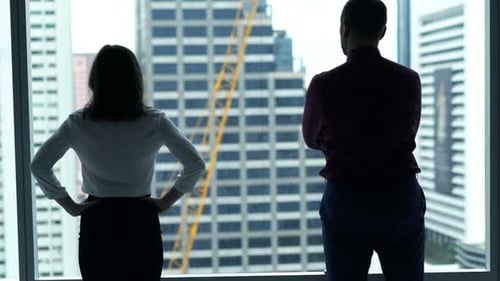 Businesspeople Admire View Standing by Window in Office 30s