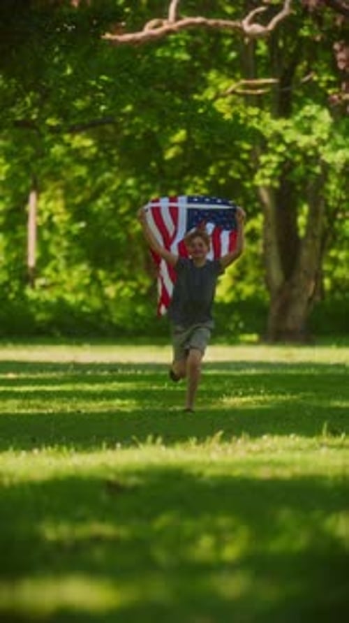 Boy Running with American Flag in Park