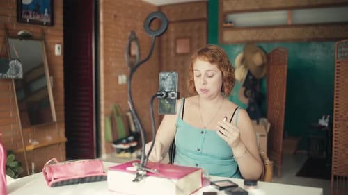 Woman Applies Lipstick at Table with Ring Light