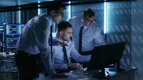 Three Men Working Together on Computer in Office