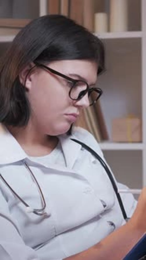 Doctor Writes Notes on Clipboard in Office