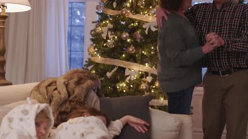 Couple Dancing at Christmas with Children on Couch