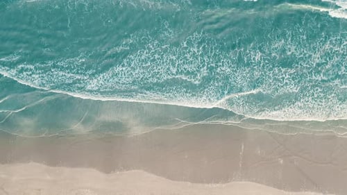 Drone aerial view of paradise beach. Turquoise sea water and clear sand at sunset.