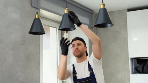 Man Installing Light Bulb in Modern Home