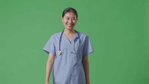 Asian Female Doctor With Stethoscope Walking On Green Screen Background In The Hospital