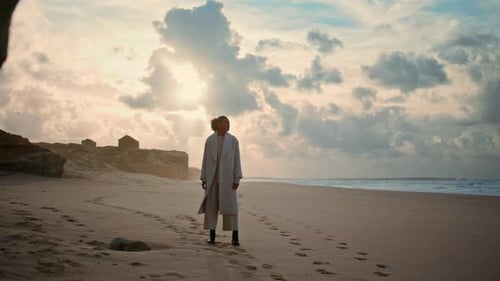 Serene Woman Admiring Ocean Beach on Cloudy Day