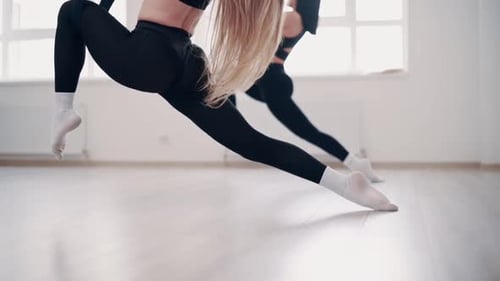Women suspended in aerial yoga hammocks
