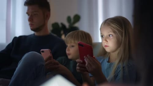 Family Using Phones in Dark Room