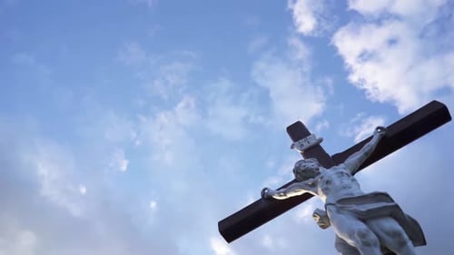 Stone Jesus Statue on Cross with Clouds