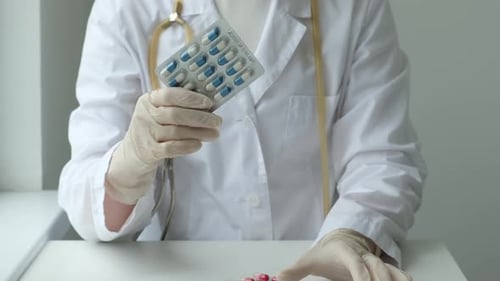 Doctor Holding Blister Pack of Pills in Clinic