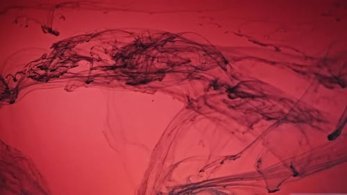 Black Ink Swirling on Red Abstract Background