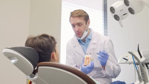 Joyful Little Boy Beams at the Camera During a Dental Checkup with His Friendly Dentist
