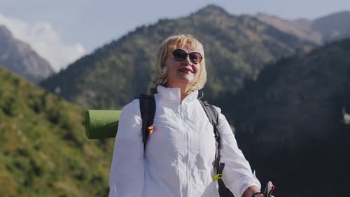 Woman Hiking Mountain with Blonde Hair and Sunglasses
