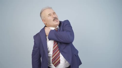 Adult Man in Suit Rubbing His Neck and Shoulder