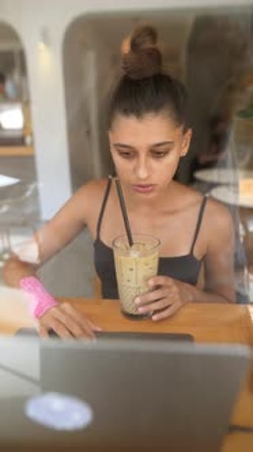 Young Woman Enjoying Iced Drink in Cozy Caf Setting
