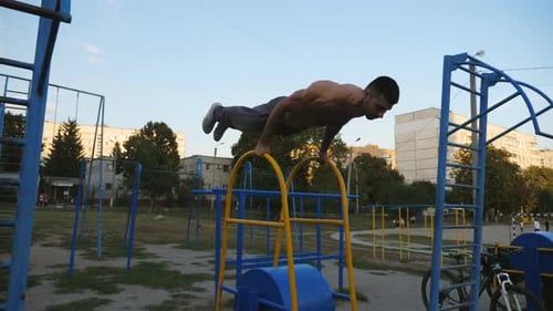 Strong Man Doing Push Ups on Sports Equipment at Playground