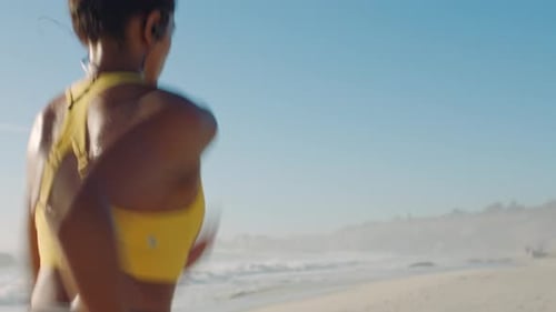 Active, fit and sporty athlete running, jogging and sprinting on a sunny beach shore